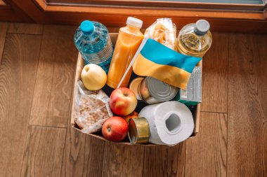  Ukraynalı çocuklar ve insanlar için farklı market ürünlerinin olduğu kağıt dolu bir bağış kutusu. Ukrayna Bağışı. Gönüllü olmak, bağışta bulunmak, yardım amaçlı mülteciler, savaş..