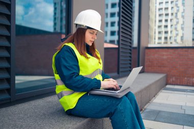 Büyük inşaat sahasında tablet bilgisayar kullanan sanayi mühendisi kadın. 