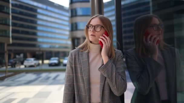 Femme d'affaires créative portant des vêtements élégants en utilisant un smartphone près du loft immeuble de bureaux — Video