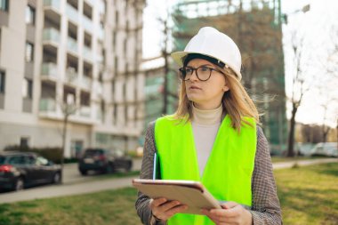 İnşaat alanında çalışan tabletli bir kadın mühendis.. 