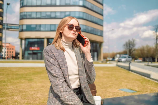 30 'lu yaşlarda, keyifli bir bayan. Dışarıda dinlenirken arkadaşıyla cep telefonuyla konuşuyor. Cep telefonuyla konuşan mutlu bir kadın. 