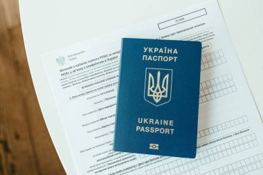 PESEL belgesi, Ukrayna pasaportu ve beyaz masa zemininde bir kalem.