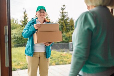 Posta servisi dışarıdaki bir evin önündeki müşteriye karton kutu gönderiyor. Nakliye servisi geliyor ve müşteri adresine gönderiliyor