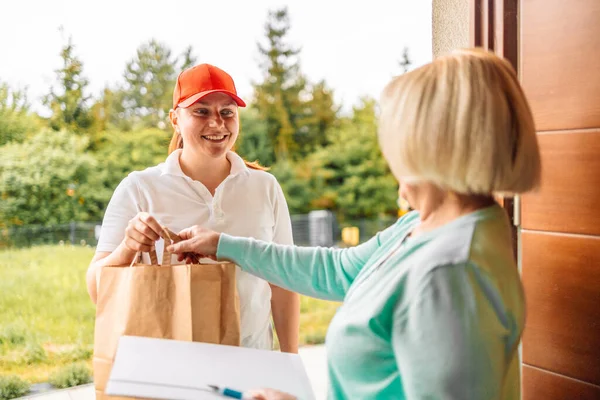 Closeup shot of an unrecognisable woman signing for his delivery from the courier. cargo shipping, express delivery service, online shopping and logistic concept — Photo