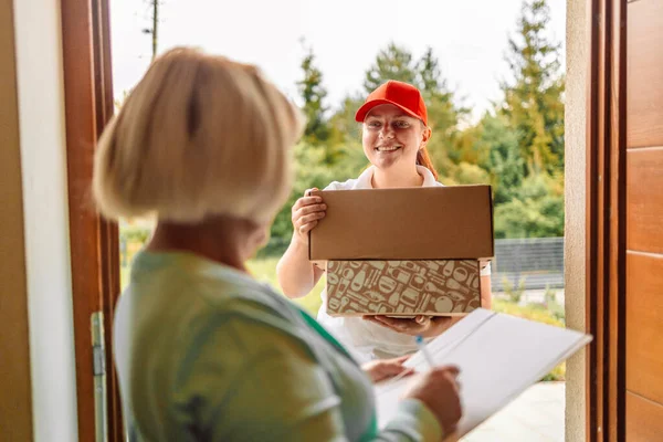 Caucasian delivery woman deliver box parcel package to customer at home, shipping delivery concept. — Photo