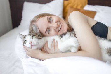 Şirin tekir kedi mutlu kadınların elinde uyur. Evinde sahibi olan tüylü evcil hayvan.. 