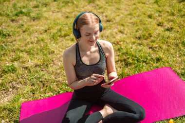 Kadın spor aktiviteleri programları cep telefonuyla senkronize verileri eşgüdümlüyor sağlık uygulamaları kablosuz olarak kontrol ediliyor kulaklıklarda ses şarkıları dinleniyor metabolizma oranını artırmak için açık havada egzersiz yapılıyor.. 