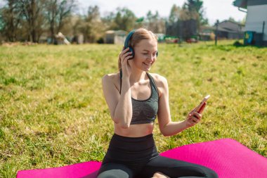 Kadın spor aktiviteleri programları cep telefonuyla senkronize verileri eşgüdümlüyor sağlık uygulamaları kablosuz olarak kontrol ediliyor kulaklıklarda ses şarkıları dinleniyor metabolizma oranını artırmak için açık havada egzersiz yapılıyor.. 