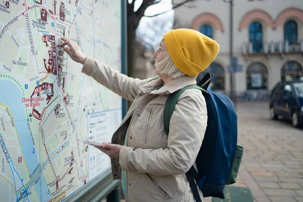 Blonďatá Turistka Let Batohem Dláždí Trasu Mapě Stánku Městě Koncept — Stock fotografie