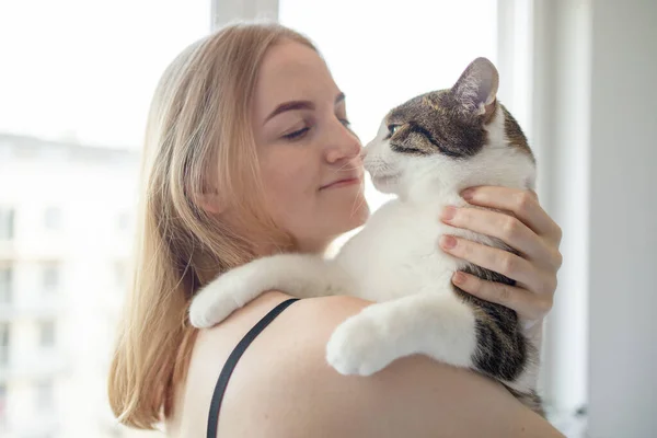 Female hugging cat in hands at home. Stay home stay safe. Love, care, adoption