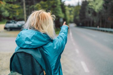 Sırt çantasıyla gezen beyaz tenli gezgin, el kol hareketleriyle dağ doğasının yönünü buluyor. Teknoloji, internet ve seyahat macerası konsepti. Yüksek kalite fotoğraf