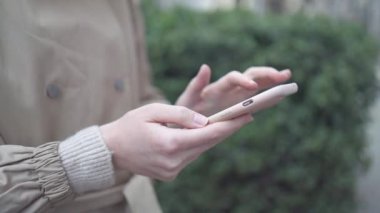 Avrupalı kadın elleri açık havada doğa koşullarına karşı akıllı telefon kullanıyor. 
