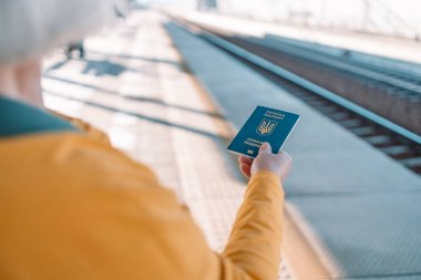 Avrupa 'da vizesiz seyahat etmek için Ukrayna biyometrik pasaport kimliği. Trip tren istasyonunda Ukrayna biyometrik pasaportlu kadın elleri. 