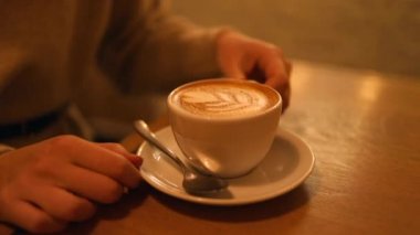 Kafede kadın eli kahve bardağını tutuyor. Yüksek kaliteli FullHD görüntüler