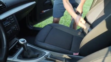 Siyah bir araba halısını elektrikli süpürgeyle temizlemek.. 