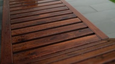 Scenic view of wooden deck chair made of tropical wood for one person in the park. High quality FullHD footage