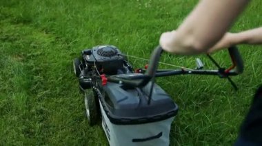 Çim biçme, çim biçme makinesi üzerinde yeşil çim biçme makinesi çim donanımları, bahçıvan bakım iş aleti, biçme yakın görünümü, güneşli bir gün
