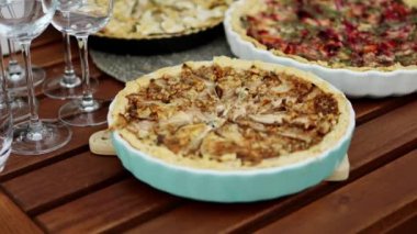 Ahşap arka planda fındıklı, bezelyeli ve peynirli ev yapımı sebze turtası. Yaz partisi konsepti