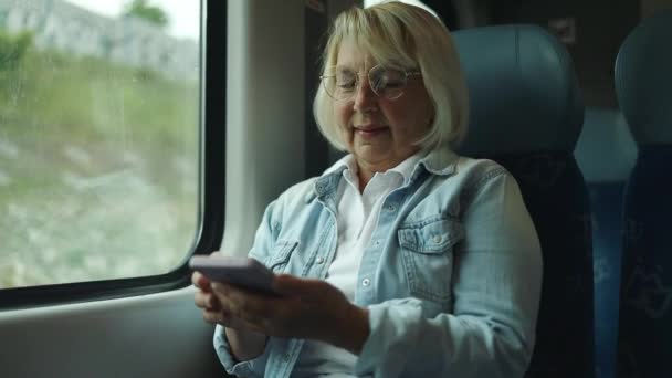 Senior Woman Glasses Looking Screen Mobile Phone Big Windows Traveling — Vídeos de Stock