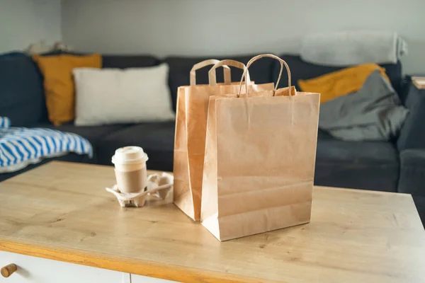 Delivery concept. Paper bags packages and coffee on a table. Contactless delivery service, food take away, lockdown, quarantine, pandemic, coronavirus covid-19, ordering food, online shopping. High