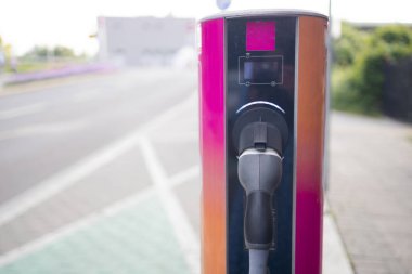 Bulanık elektrikli araba şarj istasyonu EV pili için. Elektrikli motoru olan bir araç için fiş. EV şarj aleti. Temiz enerji. 