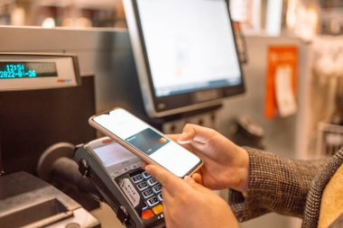 Krakow, Polonya - 26 Nisan 2022: akıllı telefondan ödeme başarıyla imzalandı. Temassız ödeme. Mobil kontrol mağazada. Müşteri deneyimi kavramı