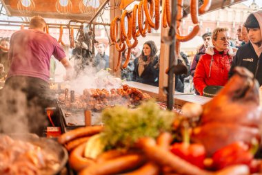 Blurry background of bbq street food for sale. Fried baked sausages, hot dog on street food outdoor market stall in Krakow Poland 