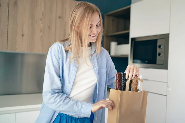 Jeune Femme Déballer Sac Papier Après Les Achats Dans Intérieur — Photo