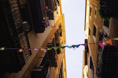 Valencia, İspanya 'da işlek bir caddede asılı renkli üçgen çelenkler. Açık hava dekorasyonu için yeşil, sarı ve kırmızı kiraz..