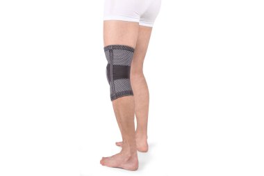 Diz Destek Kolu beyaz arka planda izole edilmiş bir bacak üzerinde. Ortopedik Anatomik Ortopedi. Diz sabitleme, yaralanma ve ağrı için diş telleri. Ortopedi. Ayak ortozu. Diz eklemi bandaj kolu. Elastik Spor