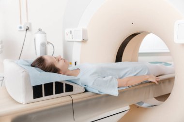 Modern hastane laboratuvarında bir hastaya tıbbi tomografi ya da MRI taraması yapın. Radyografi bölümünün içi. Beyaz odada teknolojik olarak gelişmiş ekipmanlar var. Manyetik rezonans tanılama makinesi