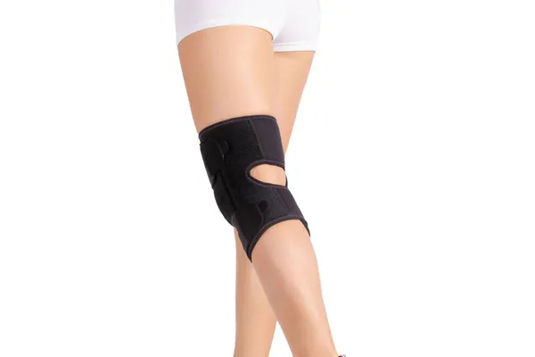 Knee Support Brace on leg isolated on white background. Orthopedic Anatomic. Braces for knee fixation, injuries and pain. Knee Joint Bandage Sleeve. Elastic Sports — Stock Photo, Image