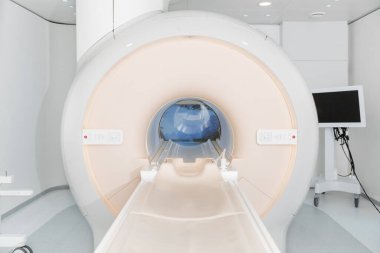 Modern hastane laboratuvarında tıbbi tomografi ya da MRI taraması. Radyografi bölümünün içi. Beyaz odada teknolojik olarak gelişmiş ekipmanlar var. Manyetik rezonans tanılama makinesi