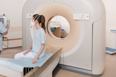 Modern hastane laboratuvarında bir hastaya tıbbi tomografi ya da MRI taraması yapın. Radyografi bölümünün içi. Beyaz odada teknolojik olarak gelişmiş ekipmanlar var. Manyetik rezonans tanılama makinesi
