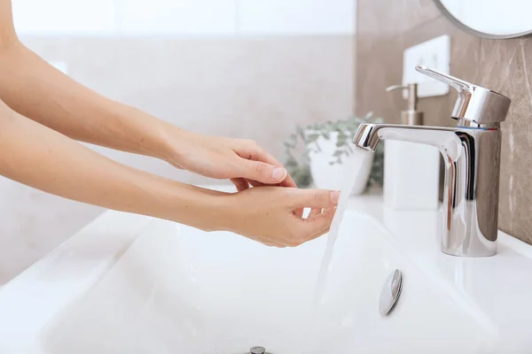 流れる水の下で手を洗う。衛生コンセプトの手の詳細。手を洗うには、コロナウイルスの予防、コロナウイルスの拡散を停止する衛生、または公共の洗面所の石鹸でこすり — ストック写真