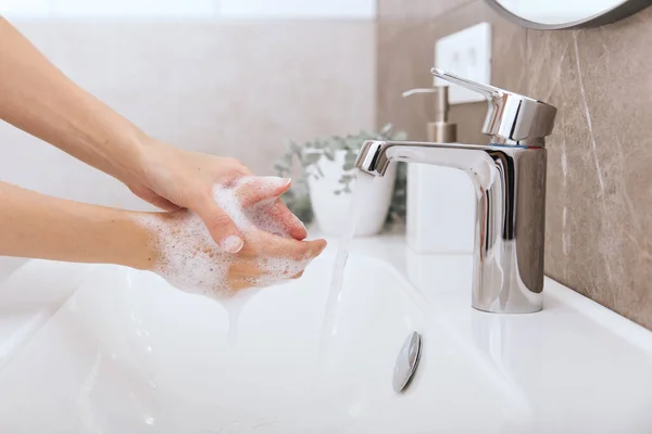 Washing hands under the flowing water tap. Hygiene concept hand detail. Washing hands rubbing with soap for corona virus prevention, hygiene to stop spreading corona virus in or public wash room — Stock Photo, Image