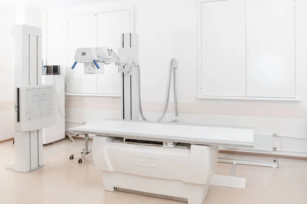 Departamento de raio-X no hospital moderno. Sala de radiologia com máquina de varredura com cama vazia. Técnico ajustando uma máquina de raios-x. Escaneamento de tórax, coração, pulmões no consultório de clínica moderna — Fotografia de Stock