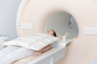 Modern hastane laboratuvarında bir hastaya tıbbi tomografi ya da MRI taraması yapın. Radyografi bölümünün içi. Beyaz odada teknolojik olarak gelişmiş ekipmanlar var. Manyetik rezonans tanılama makinesi