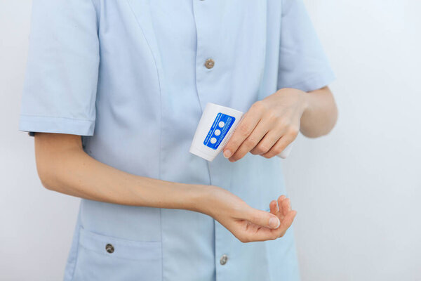 Temperature measurement gun in doctor hands. Close-up shot of doctor wearing protective surgical mask ready to use infrared isometric thermometer gun to check body temperature for virus symptoms