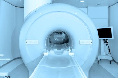 Modern hastane laboratuvarında tıbbi tomografi ya da MRI taraması. Radyografi bölümünün içi. Beyaz odada teknolojik olarak gelişmiş ekipmanlar var. Manyetik rezonans tanılama makinesi