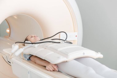Modern hastane laboratuvarında bir hastaya tıbbi tomografi ya da MRI taraması yapın. Radyografi bölümünün içi. Beyaz odada teknolojik olarak gelişmiş ekipmanlar var. Manyetik rezonans tanılama makinesi