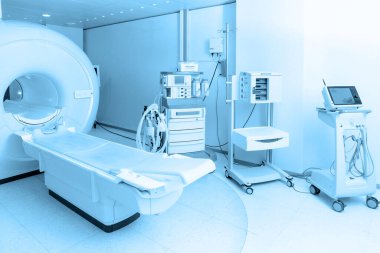 Modern hastane laboratuvarında tıbbi tomografi ya da MRI taraması. Radyografi bölümünün içi. Beyaz odada teknolojik olarak gelişmiş ekipmanlar var. Manyetik rezonans tanılama makinesi