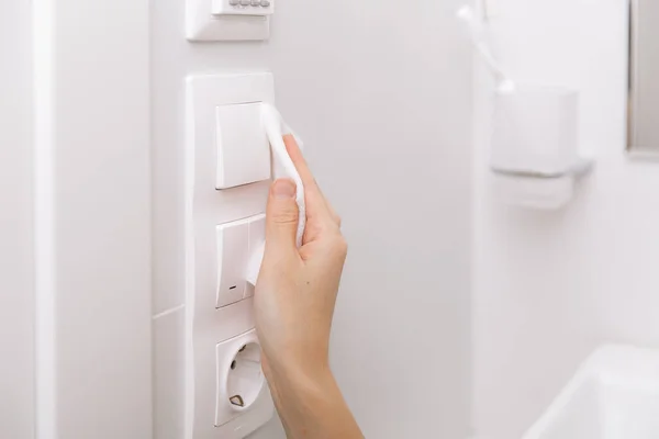 Limpar interruptores e tomadas com um pano de microfibra. Sanear a prevenção de superfícies em espaços hospitalares e públicos contra o vírus da corona. Mulher mão usando toalhete molhado para limpar casa quarto porta link — Fotografia de Stock