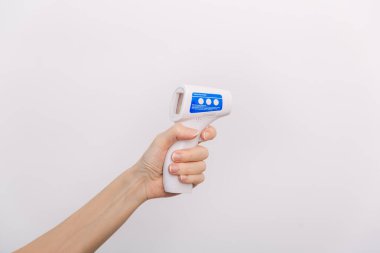 Sıcaklık ölçüm silahı doktorun elinde. Doktorun koruyucu cerrahi maske takıp vücut ısısını kontrol etmek için kızılötesi izometrik termometre tabancası kullanmaya hazır olduğu yakın çekim.