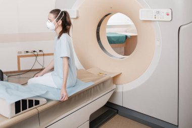 Modern hastane laboratuvarında bir hastaya tıbbi tomografi ya da MRI taraması yapın. Radyografi bölümünün içi. Beyaz odada teknolojik olarak gelişmiş ekipmanlar var. Manyetik rezonans tanılama makinesi