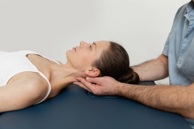 Osteopatik boyun ve omuz tedavisi gören kadın hasta. Kafa ve göğsün arkasını manipüle eden bir terapist. CST tedavisi gören bir kız. Osteopatik yönlendirme ve terapi