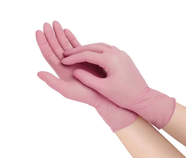 Медицинские перчатки. Две розовые хирургические перчатки изолированы на белом фоне с руками. Изготовление резиновых перчаток, человеческая рука в латексной перчатке. Врач или медсестра надевают защитные перчатки — стоковое фото