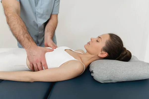 Osteopathic belly massage. Female patient receiving osteopathic belly or tummy treatment. Osteopathic manipulation and therapy. Manual therapist manipulates womans belly — Stock Photo, Image