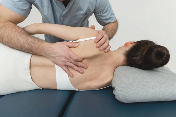 Back massage. Chiropractor or osteopath fixing back during visit in manual therapy clinic. Doctor doing shoulder blade therapy. Scoliosis. Posture Correction. Chiropractic treatment, Back pain relief — Stock Photo, Image