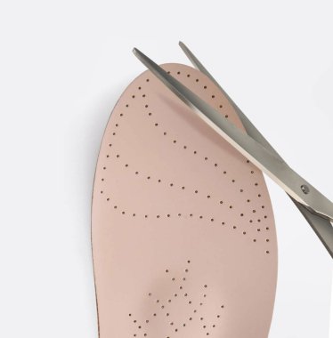 Beyaz arka planda ortopedik taban. Düz taban ve ayak hastalıklarının tedavisi ve önlenmesi. Ayak bakımı, ayaklara iyi gelir. Rahat ayakkabılar giy. Tıbbi tabanlar. Düz Ayak Düzeltme